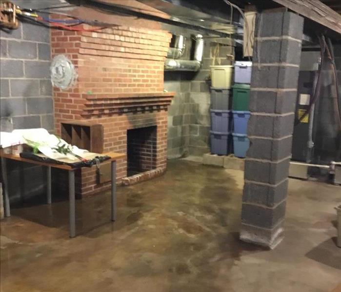 brick fireplace, block support column and heavy beams along with stored bins and a still slightly wet floor